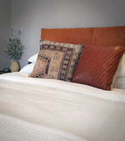 woven leather headboard and vintage pillows