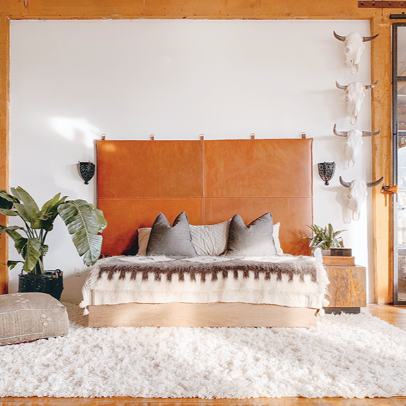 large wall mount leather headboard in loft with white shag rug