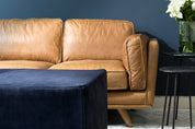 leather sofa against blue wall with suede ottoman