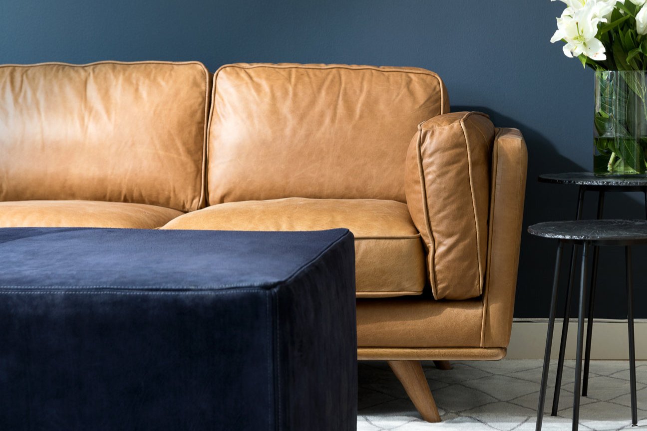 leather sofa against blue wall with suede ottoman