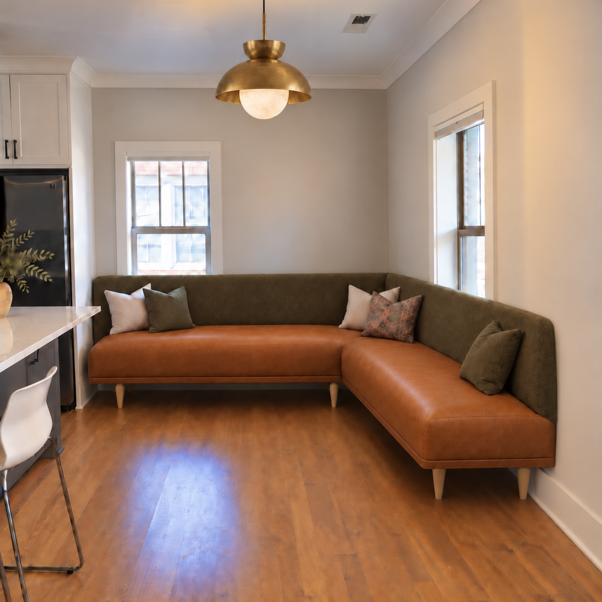 HF Atelier custom L-shaped dining banquette in cognac leather and olive velvet with recessed maple legs