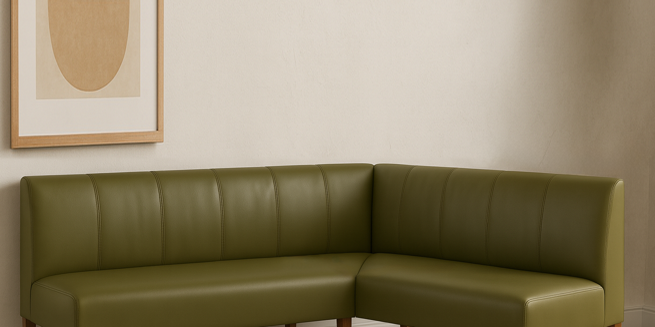 Green leather sectional sofa in a room with a abstract painting on the wall.