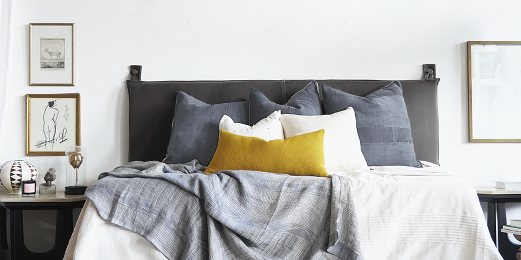 black leather wall-mount headboard on king bed in minimalist room