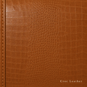 Close-up of brown crocodile leather texture with stitching detail